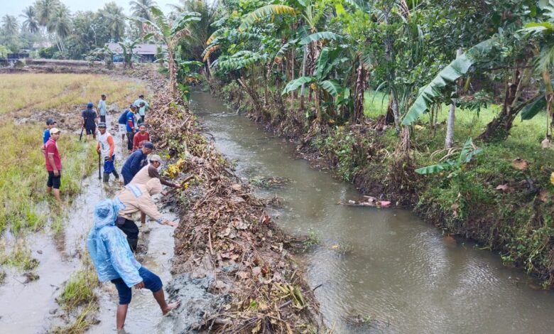 Bhabinkamtibmas Polsek Toili Bersama Warga Gotong Royong Bersihkan Saluran Air