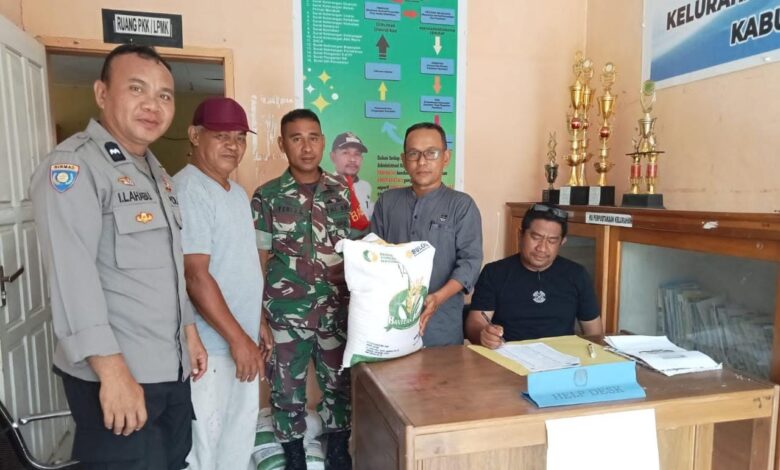 Bhabinkamtibmas Polsek Batui Kawal Distribusi Bantuan Beras Untuk Warga Penerima Manfaat